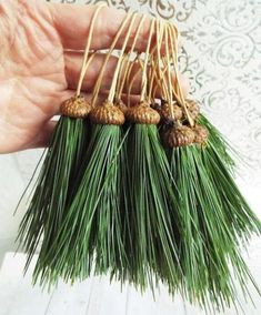 small pine cones and needles are held in the palm tree's hand, which is holding