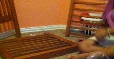 a toddler sitting on the floor playing with a wooden bed frame and foot board