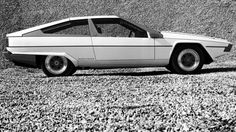 a white car parked on top of a gravel field