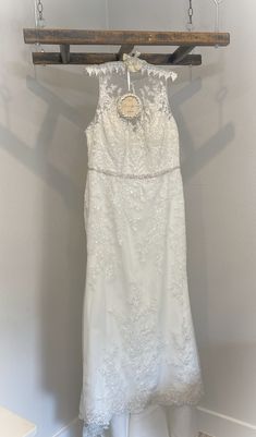 a white dress hanging on a wooden hanger