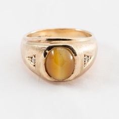 Hello. This is a pretty Tiger Eye vintage ring with diamond accents in 10k yellow gold. It's marked 10k on the inside of the ring. The Tiger Eye is oval and measures approximately 10mm. The diamond accents are genuine earth mine stones. The ring finger size is 8. Sorry, we do not resize rings. The weight with the stone is 8.9 grams. Thanks for looking. Gold Oval Cabochon Diamond Ring, 14k Yellow Gold Diamond Ring Oval Cabochon, Gold Diamond Ring With Oval Cabochon Center Stone, Gold Oval Cabochon Diamond Ring For Anniversary, Gold Oval Cabochon Birthstone Ring For Anniversary, Heirloom Gold Opal Ring With Diamond Accents, Oval Birthstone Ring With Diamond Accents In 14k Gold, 14k Gold Oval Birthstone Ring With Diamond Accents, Gold Rings With Diamond Accents And Oval Cabochon