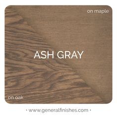 the ash gray logo is on top of a wood grained surface with white lettering