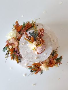 a cake decorated with flowers and pine cones