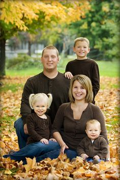 a family is posing for a photo in the leaves