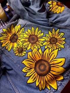 a jean jacket with sunflowers painted on it