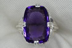 "For sale here is a very high quality amethyst ring. The genuine earth mined amethyst is a vivid purple colour. This size 6 3/4 ring is made of solid sterling silver and can be sized up or down by as much as 2 sizes for $25. This item is brand new and was appraised by a gemologist at Canadian Federal Gemological Laboratory of Canada.  The appraisal will be included with the item. The amethyst is described in the appraisal as follows:  \"Shape and cut: Rectangular Weight: 10.54 ct Species: Natural Quartz Variety: Amethyst Colour: Purple Transparency: Transparent Luster: Vitreous Refractive Index: 1.55 - 1.56 Identifying characteristics: Internal M.S.R.P: $740.00 CAD\" Please feel free to browse my shop for hundreds of additional pieces of certified gemstone jewelry including an excellent se Faceted Purple Amethyst Ring For Formal Occasions, Classic Purple Amethyst Ring, Classic Large Stone Amethyst Ring For Formal Events, Classic Amethyst Gemstones For Anniversary, Formal Faceted Amethyst Ring, Formal Faceted Purple Amethyst Ring, Classic Formal Amethyst Ring With Large Stone, Classic Lavender Amethyst Ring, Classic Purple Amethyst Ring With Prong Setting