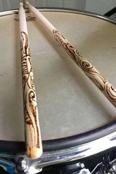 two wooden sticks sitting on top of a drum