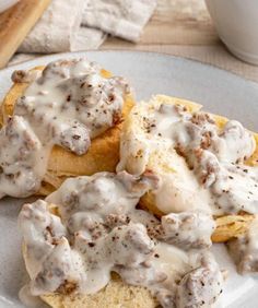 a white plate topped with biscuits covered in gravy