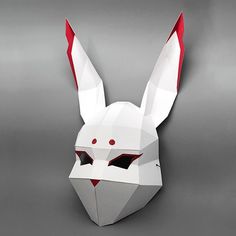 an origami rabbit mask with red eyes on a gray background, in the shape of a bunny's head