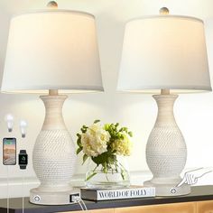 two white lamps sitting on top of a table