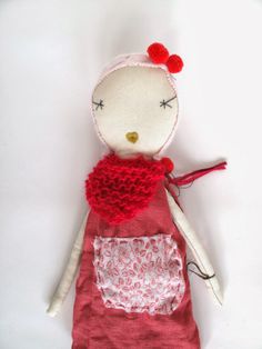 a stuffed animal with a red dress on it's body and a white background