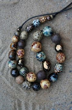 a beaded necklace is laying on the sand