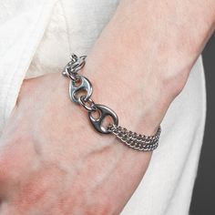 DESCRIPTION: This Pluto bracelet is robust yet comfy. It is made of tarnish resistant stainless steel and finished with a swivel lobster clasp closure. Unique polished liquid like links and a looped rounded curb chain come together with thoughtful construction. Available in four sizes, this bracelet is made just for you. DETAILS: available in 4 sizes 1.5 adjustable tail chain Rhodium plated Hematite stone stainless steel grunge aesthetic modern futuristic unisex FIT: Model has a 7 inch wrist and Metal Cuban Link Bracelet With Oval Links, Cuban Link Bracelet With Curb Chain In Metal, Metal Cuban Link Bracelet With Curb Chain, Modern Cuban Link Metal Bracelet, Trendy Metal Chain Bracelet With Curb Chain, Trendy Metal Curb Chain Bracelet, Metal Cuban Link Bracelet, Casual Metal Chain Bracelet For Everyday, Nickel-free Stainless Steel Casual Jewelry