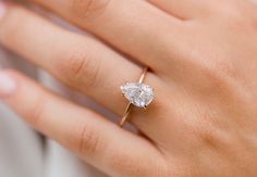 a woman's hand with a diamond ring on it