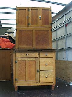 an old wooden cabinet sitting in the middle of a room with other furniture on top of it