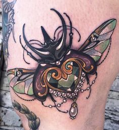 a close up of a person's leg with an insect tattoo design on it