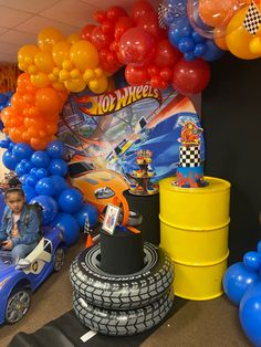 a room filled with balloons and toys in the shape of cars, trucks, and motorcycles