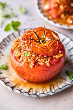 an open tomato on a plate with other food items in the bowl behind it and another dish to the side