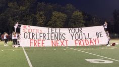 a group of people standing on top of a football field holding a banner that reads, hey scotties tell your girlfriends you'll be free next friday