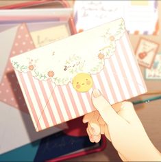 a hand holding an open envelope with a smiley face on it and flowers around the edges