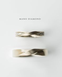 two rings with diamonds on them sitting side by side in front of the words mano diamond