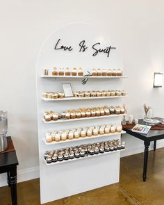 there are many cupcakes on the shelves in this bakery display case that says love and sugar