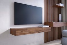 a flat screen tv mounted to the side of a wooden shelf in a living room