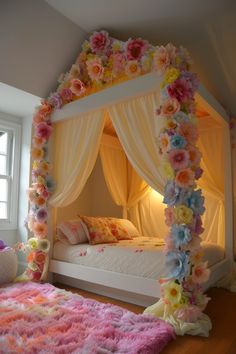 a canopy bed decorated with flowers and white drapes