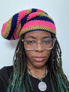 a woman with dreadlocks wearing glasses and a knitted hat on her head