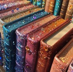 many books are lined up in rows with colorful glitters on the covers and pages