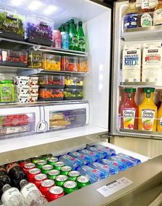 an open refrigerator filled with lots of drinks and condiments on the shelves next to each other