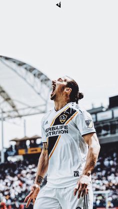 a soccer player with his mouth wide open in front of an audience at a sporting event