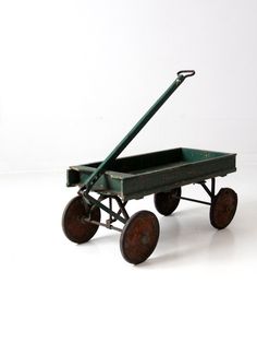 an old green wagon with wheels on a white background