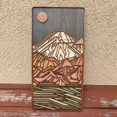 a piece of wood with mountains on it