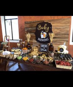 a table filled with food and drinks next to a wooden sign that says baby brewing