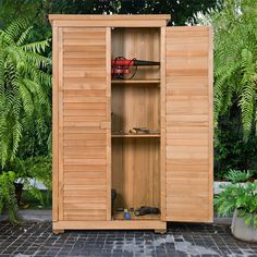 a wooden storage cabinet sitting in the middle of a garden