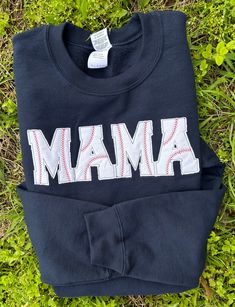 a sweatshirt with the word mamma printed on it laying in some grass next to a pair of scissors