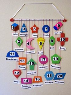 a bulletin board with numbers and shapes hanging from it's sides on a wall