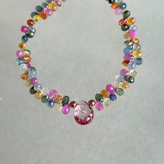 This one of a kind, handmade necklace features a central pink topaz briolette inset with a 1.5mm (approximately 1.5 point) diamond in a 14k gold bezel. Other stones in the necklace are multicolored sapphire microfaceted briolettes ranging from 4mm to 6mm long and small faceted rondels at the end of the necklace.  Length is 16" with a new 14k rose gold toggle clasp and 14k rose gold beads on either side of the central topaz. The sapphires are for the most part transparent or moderately included, Fine Jewelry Pink Briolette Jewelry, Oval Tourmaline Necklace In Fine Jewelry Style, Fine Jewelry Pink Necklaces With Gemstone Accents, Oval Tourmaline Necklace Fine Jewelry, Fine Jewelry Multi-stone Briolette Gemstones, Elegant Pink Multi-stone Necklace, Fine Jewelry Faceted Briolette Necklaces, Fine Jewelry Briolette Faceted Necklace, Fine Jewelry Briolette Necklaces With Gemstone Accents