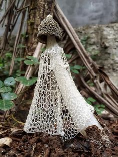 a small mushroom sitting on the ground in front of a pile of leaves and twigs