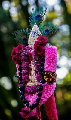 a close up of a person wearing a costume made out of flowers and feathers with beads