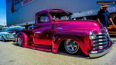 an old red truck parked in front of a building