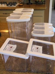 four plastic containers with labels on them are sitting on the counter in front of an oven