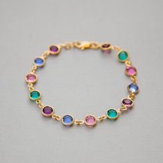 "Dainty, custom Mother's bracelet in gold with Swarovski Crystal birthstones. This sparkling birthstone bracelet would make a perfect gift for a mother or grandmother, with Swarovski crystals, set in gold, representing the birthstones of their family members. I can make this bracelet in a variety of ways for you. The photos above show some of the options: * a row of birthstones surrounded on either side by clear crystals * a repeated pattern of colors * a single color <>How to Order<&gt Multicolor Gold Bracelet For Gift, Round Birthstone Bracelets For Birthdays, Gold Crystal Bracelet For May Birthstone Gift, Adjustable Bezel Set Bracelets As A Gift, Adjustable Bracelets With Bezel Setting As Gift, Gold Gemstone Bracelet For Birthday, Gold Birthstone Bracelets For Anniversary, Yellow Gold Round Crystal Bracelet Gift, Mother's Day Gift Gold Crystal Bracelet