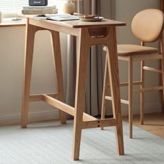 a wooden desk with two stools next to it and a window in the background