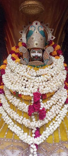 a statue is adorned with flowers and beads