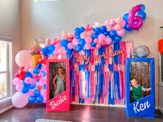 a birthday party with balloons, streamers and pictures on the wall in front of it