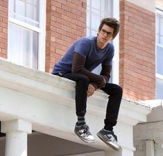 a man sitting on top of a window sill