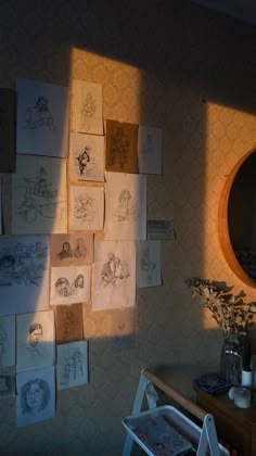 many drawings are hanging on the wall next to a mirror