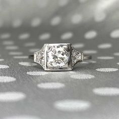 an old - fashioned diamond ring sits on a polka dot background